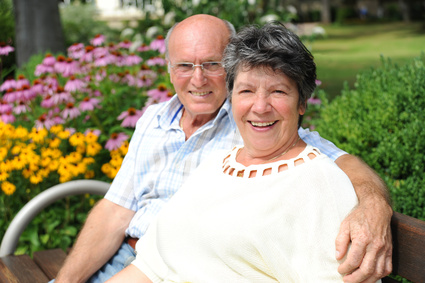 Älteres Ehepaar im eigenen Garten dank Immobilienfinanzierung